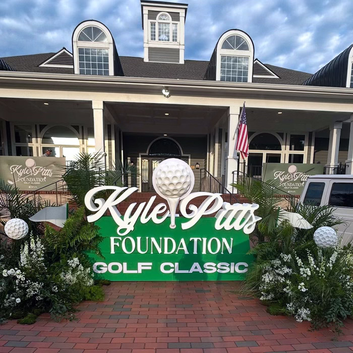 Graphic of a typography specimen showing the alphabet and numerals on top of a dark gray background.