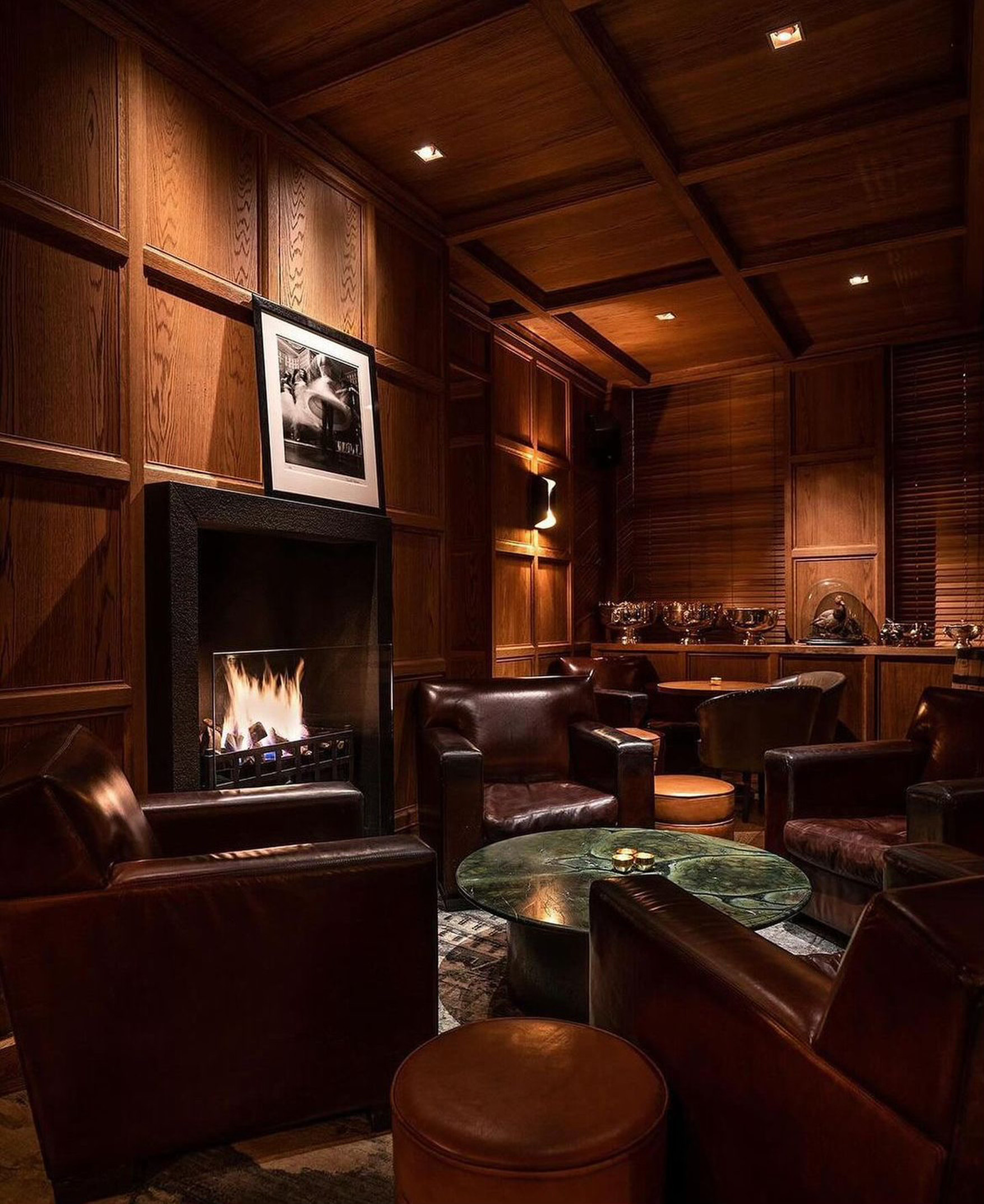 Photo of two women and a man talking in the corner of a room with modern furniture.
